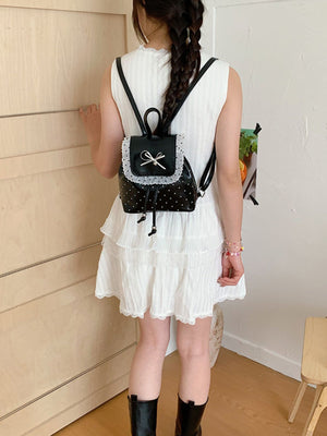 white backpack featuring lace trim and polka-dot