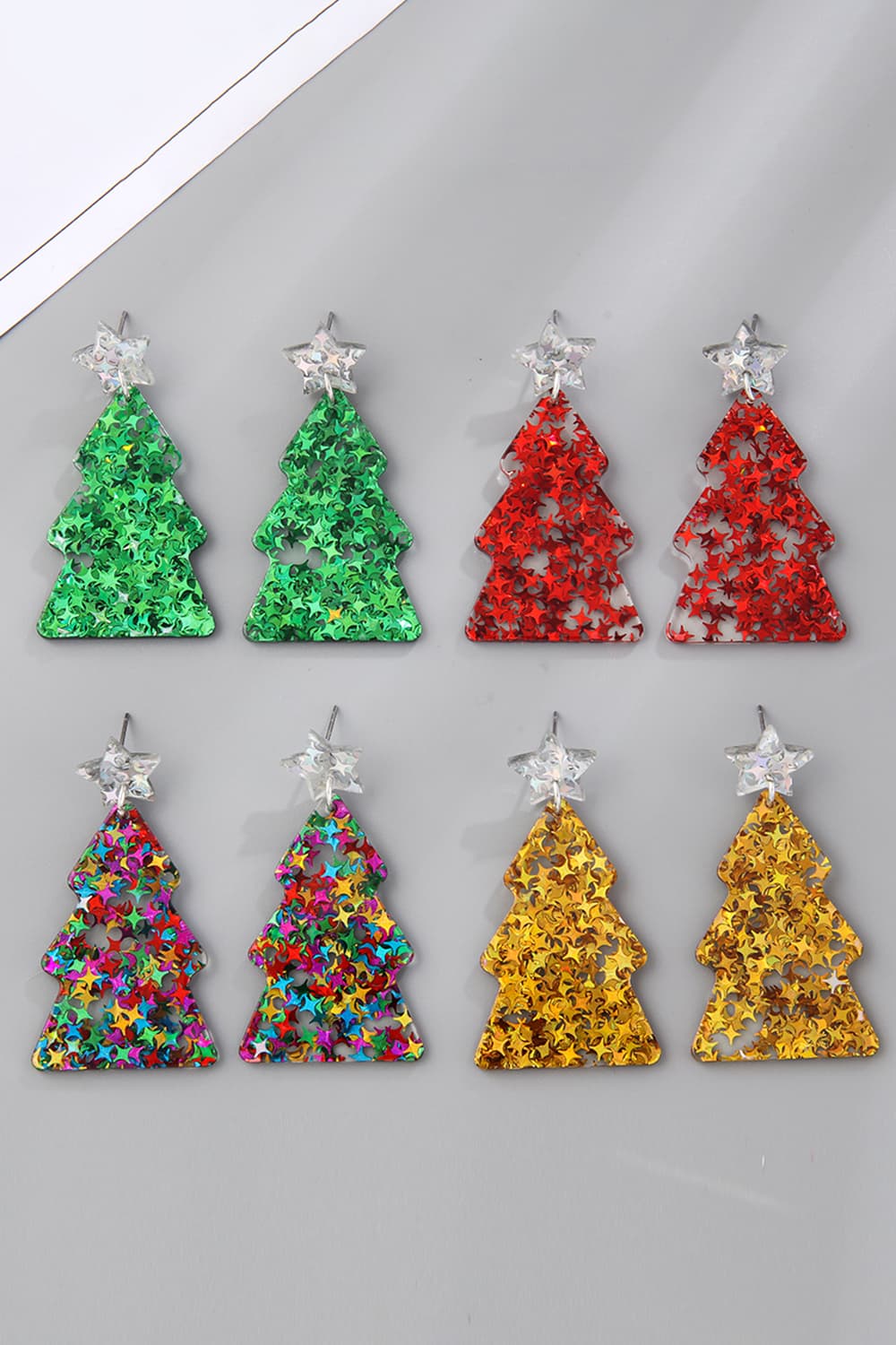 Star-studded holiday drop earrings in green, red, multi, and gold acrylic with star accents.