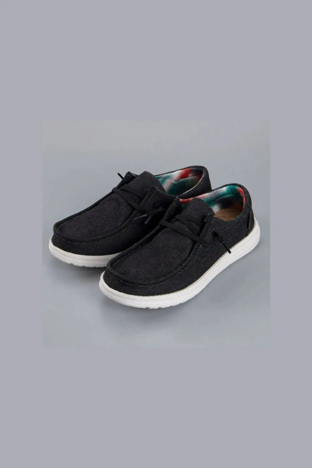 Textured slip-on espadrille sneakers in black with a colorful plaid lining.