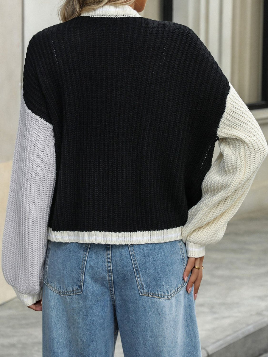 Colorblock trim knit cardigan in black with gray and cream sleeves.