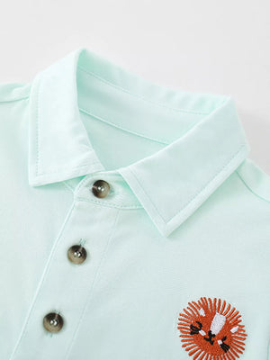Light blue baby polo shirt with embroidered lion detail and button placket.