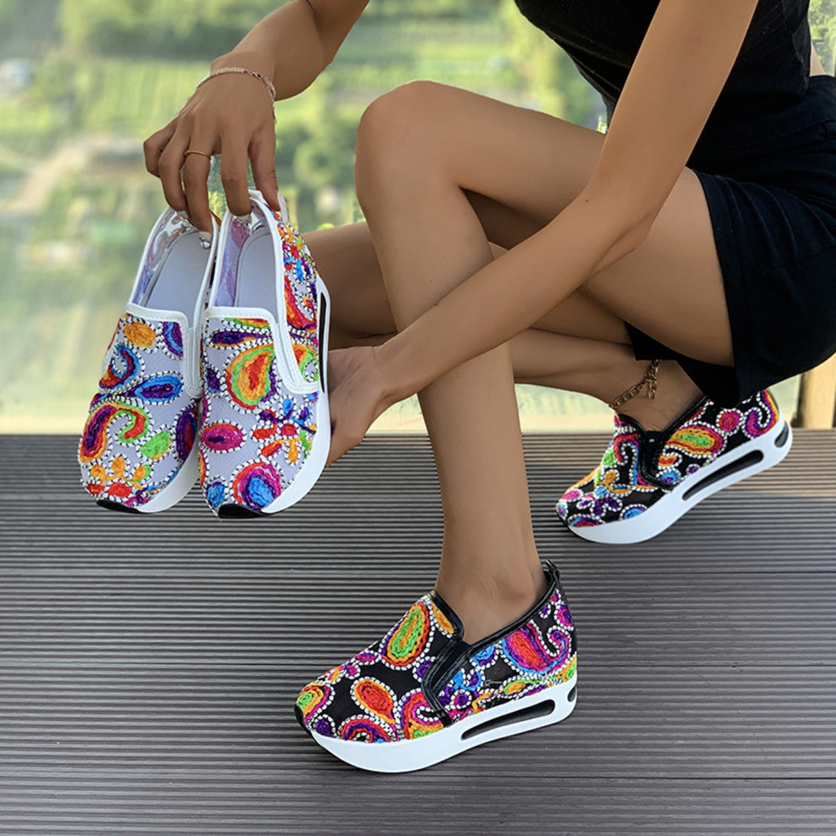 Vibrant slip-on platform sneakers with colorful paisley print and white soles.