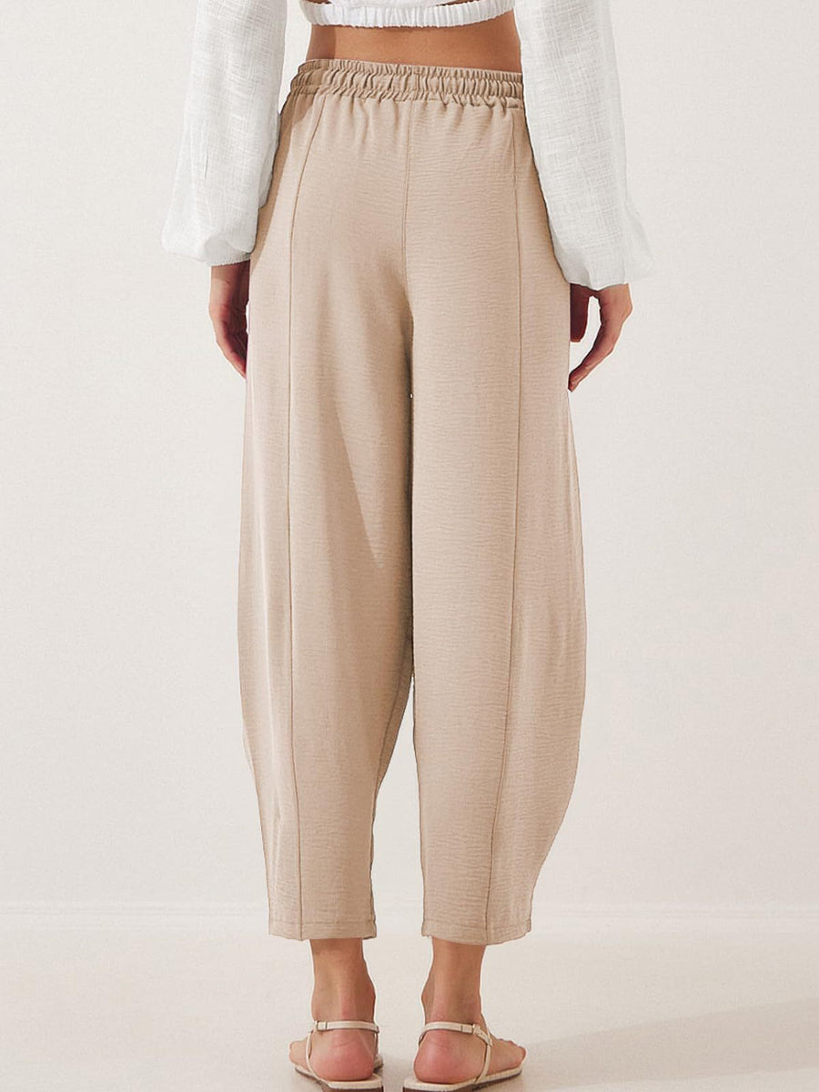 Tan balloon trousers with sculpted seamlines and elastic waistband, cropped length
