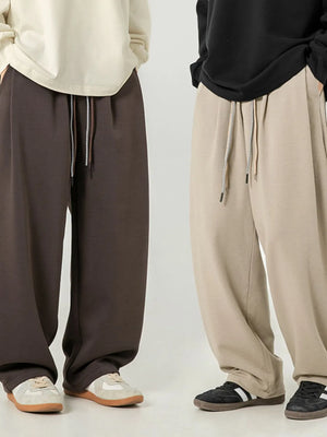Oversized drape-front lounge trousers in coffee brown and khaki with drawstring waist.