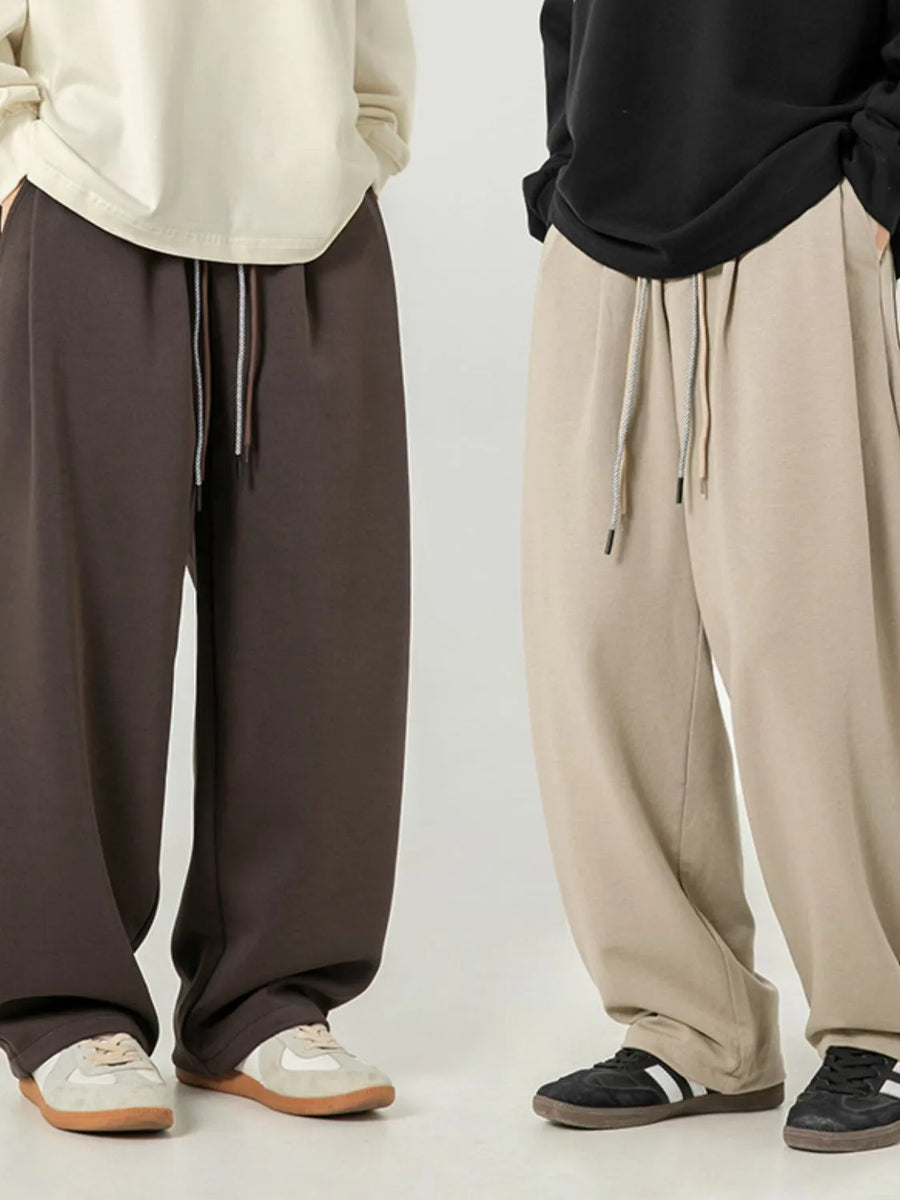 Oversized drape-front lounge trousers in coffee brown and khaki with drawstring waist.