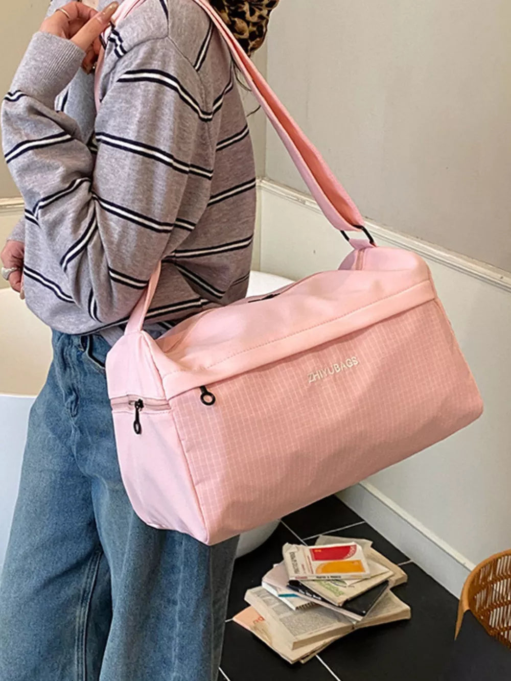 Pink travel organizer bag with subtle grid pattern and zippered front pocket.
