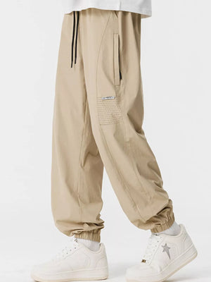 Khaki jogger sweatpants with drawstring and perforated pocket detail.