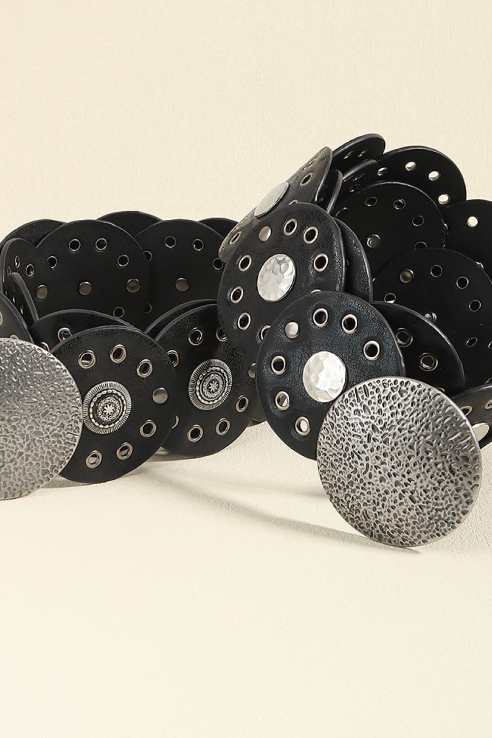 Black faux leather belt with round disc embellishments and silver hardware.