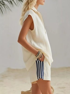 Cream linen sleeveless collared zip-up top and striped shorts with pockets.