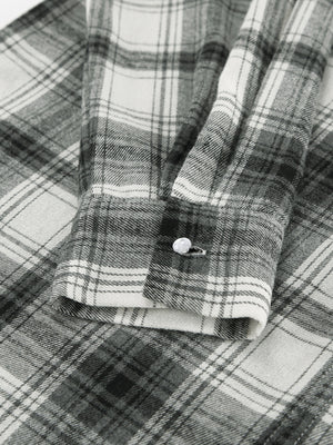 Button-up long sleeve cotton shirt in black and white plaid with a single button cuff detail.