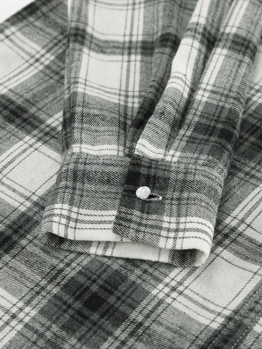 Button-up long sleeve cotton shirt in black and white plaid with a single button cuff detail.