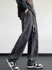 Oversized dark gray denim jeans with drawstring waist and loose fit.