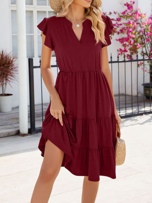 Burgundy ruffled midi dress with notched V-neck and tiered skirt.