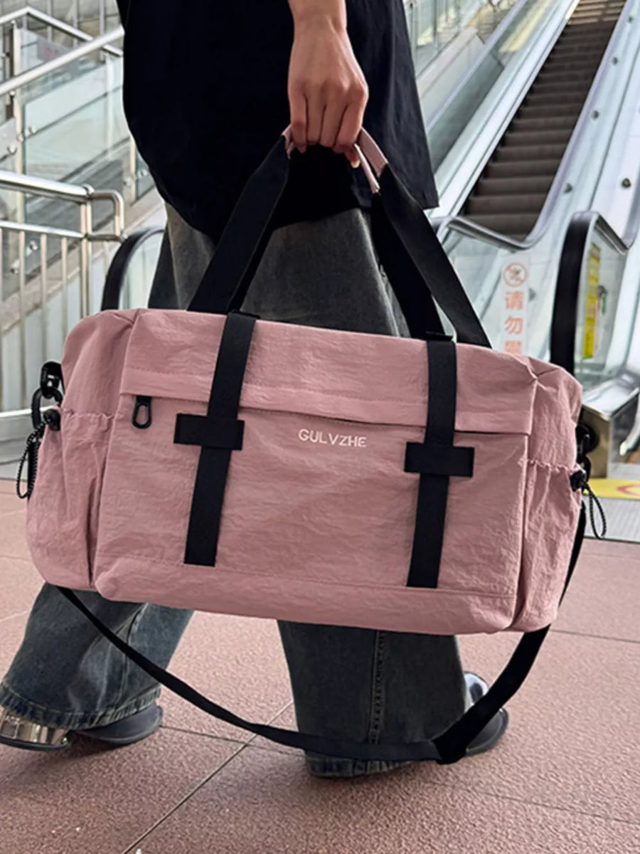 Pink duffel bag with black straps and adjustable strap, casual style