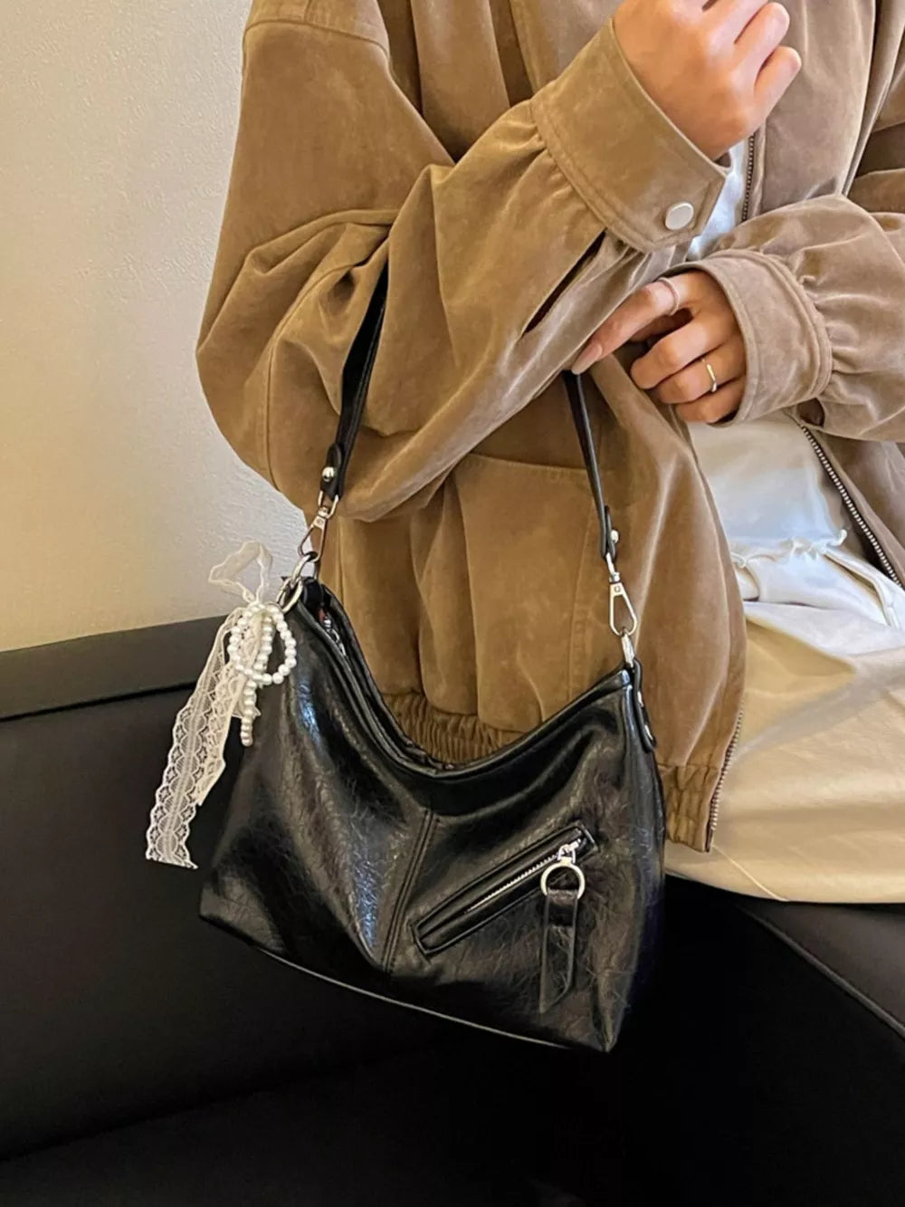 handbag in black featuring exterior zip pocket and slouchy fit
