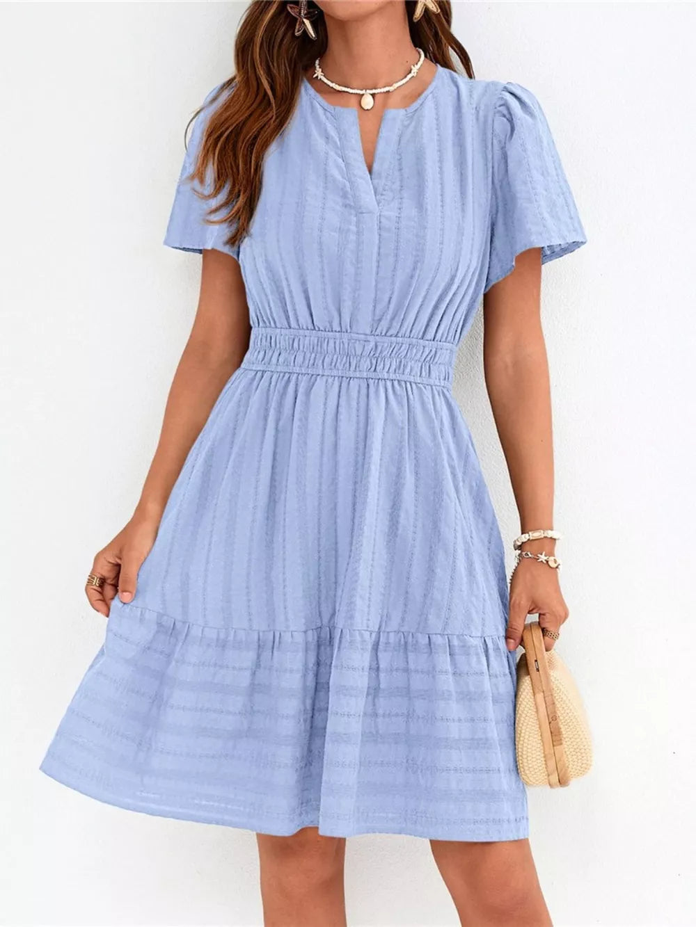 Light blue textured V-neck tiered dress with smocked waist and short sleeves.
