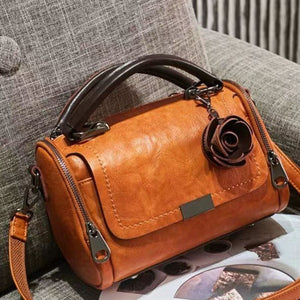 crossbody bag in cognac featuring top handle and structured fit