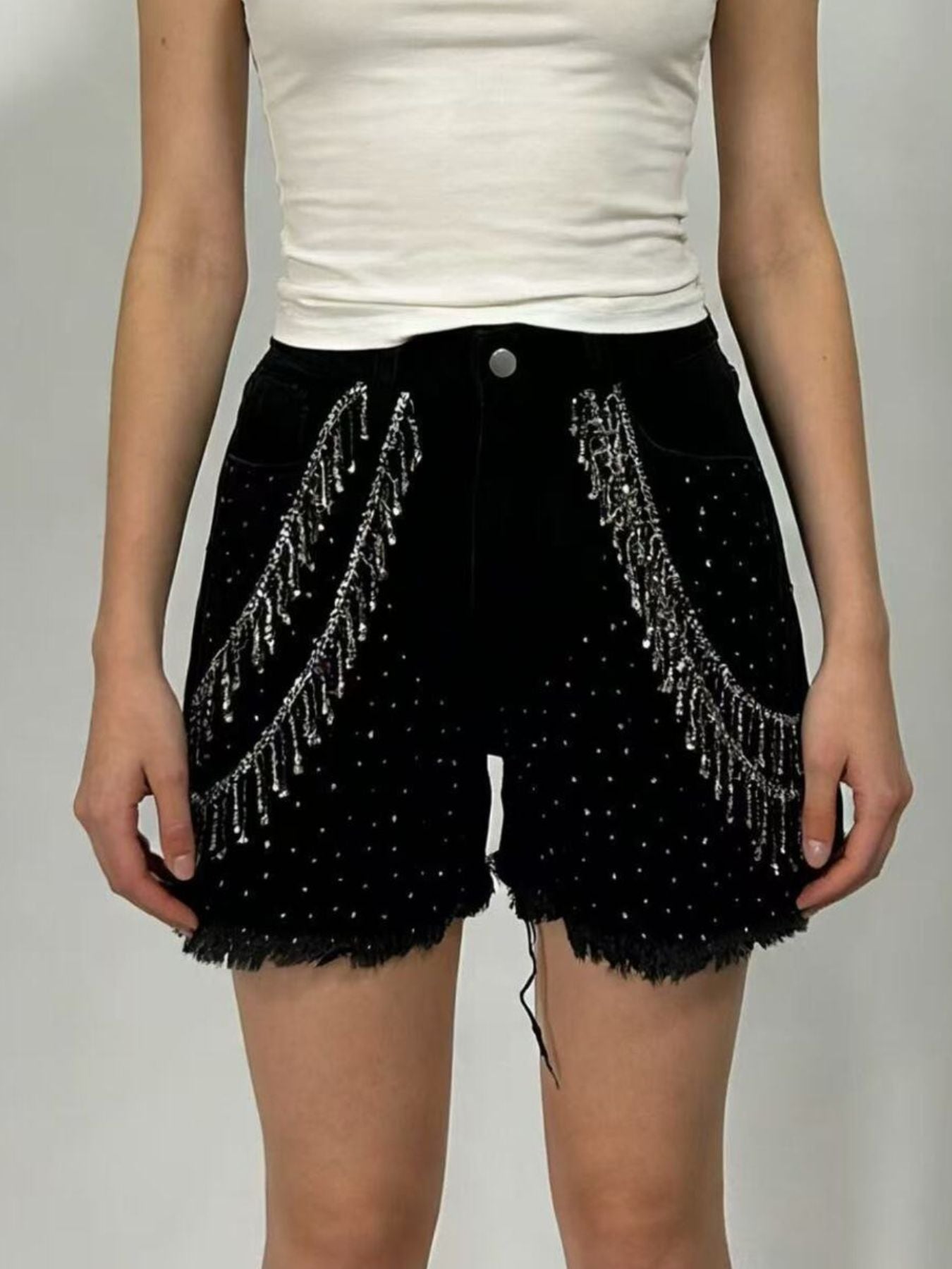 Black denim shorts with rhinestone embellishments and chain fringe detail.