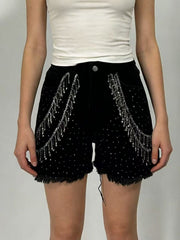 Black denim shorts with rhinestone embellishments and chain fringe detail.