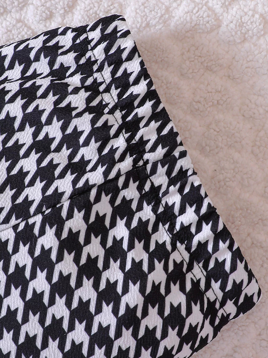 Baby pants with black and white houndstooth pattern and stitched details.