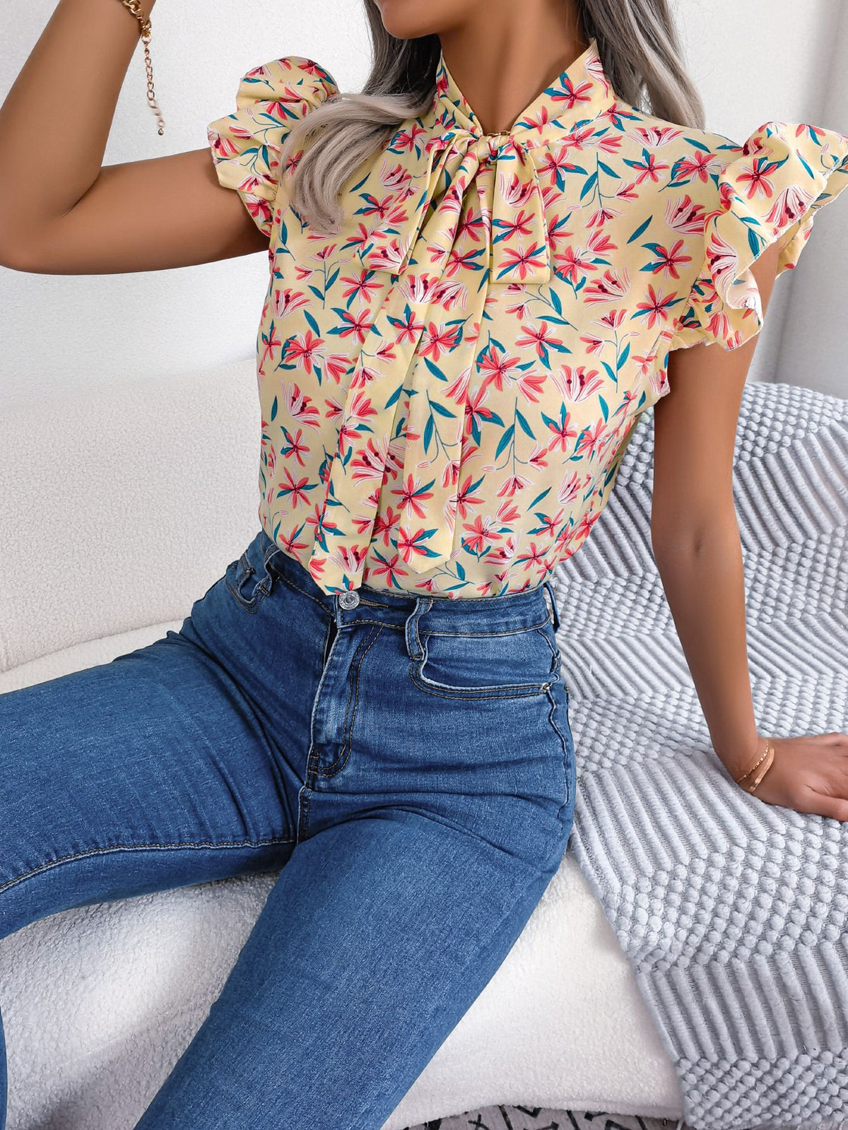 Apricot floral neck-tie blouse with ruffle sleeves and a tie neck.