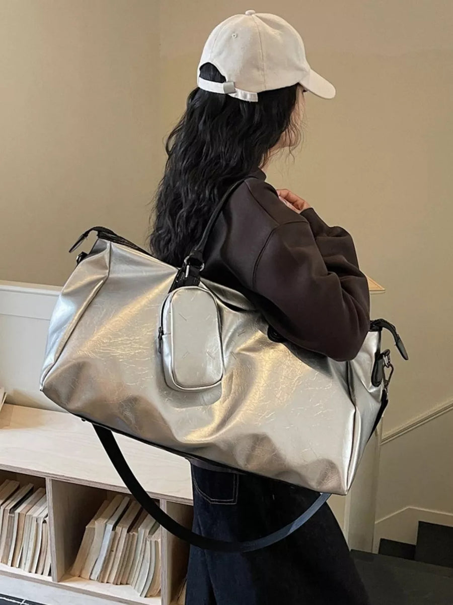 Sleek silver metallic large travel bag with adjustable strap and front pouch.