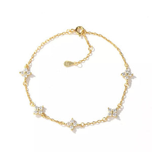 Gold chain bracelet with five sparkling clover charms.