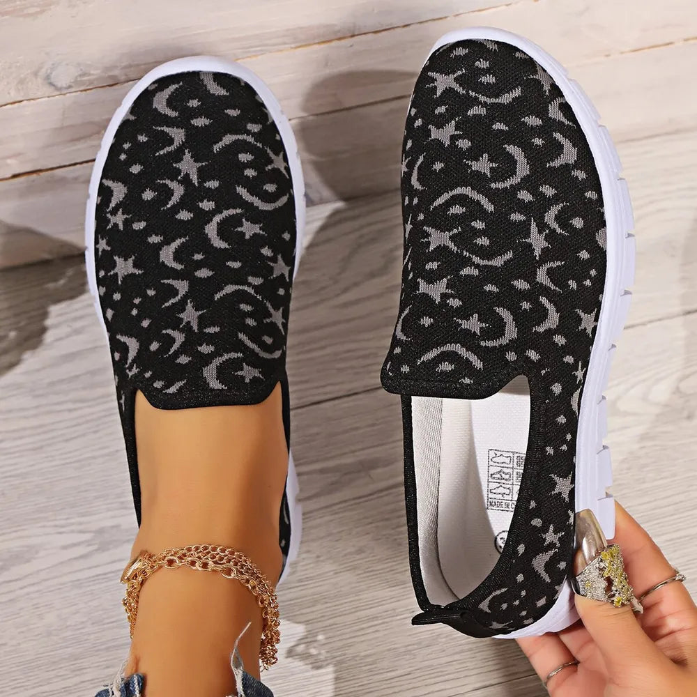 Black celestial knit slip-on sneakers with moon and star pattern