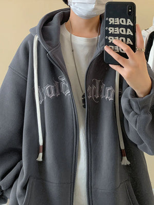 Gray zip up hoodie with white drawstring and gothic font graphic.