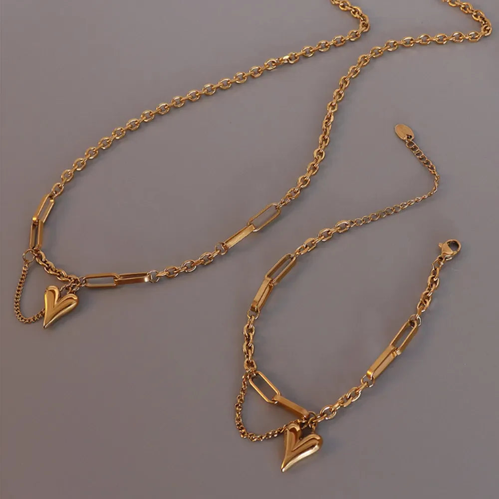 Gold heart drop chain link necklace with paperclip chain detail.
