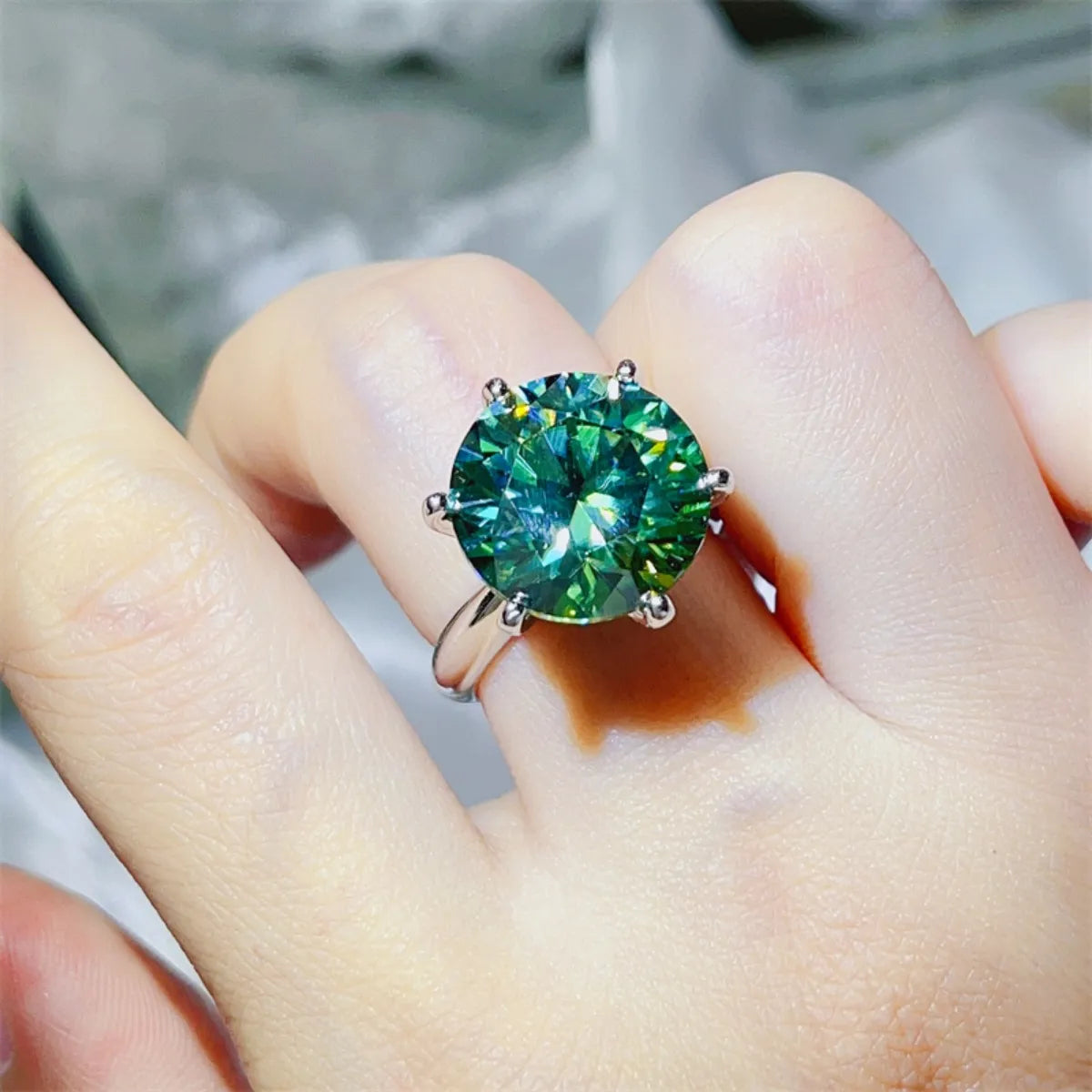 Green moissanite solitaire ring in 925 sterling silver with six prongs.