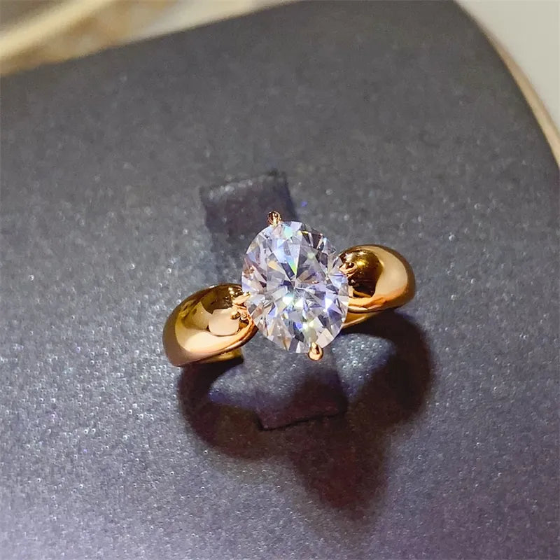 Gold oval moissanite solitaire ring with sculpted band.