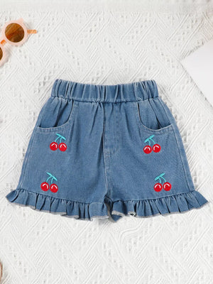 Denim shorts with cherry embroidery and ruffle trim.
