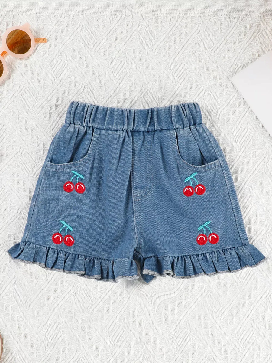 Denim shorts with cherry embroidery and ruffle trim.