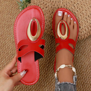 Chic red open-toe sandals with golden oval accent and contrast stitching.
