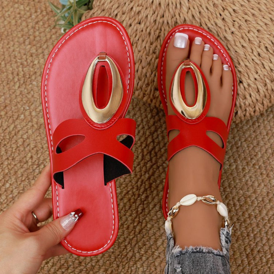 Chic red open-toe sandals with golden oval accent and contrast stitching.