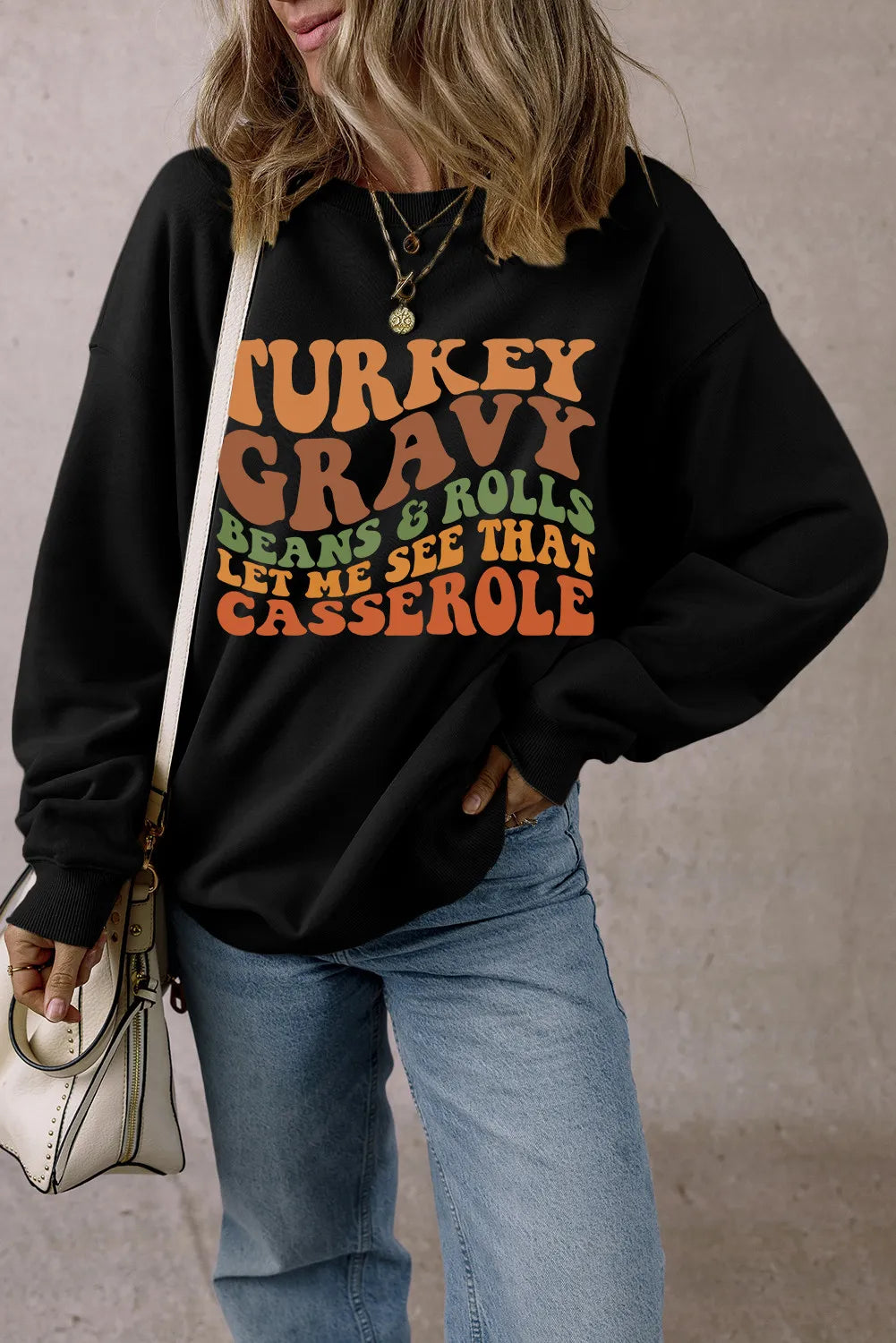 Black crewneck sweatshirt with Thanksgiving graphic text.