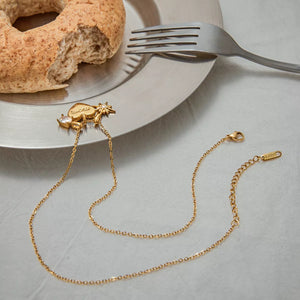 Gold heart charm necklace with cubic zirconia and starburst detail, dainty chain.