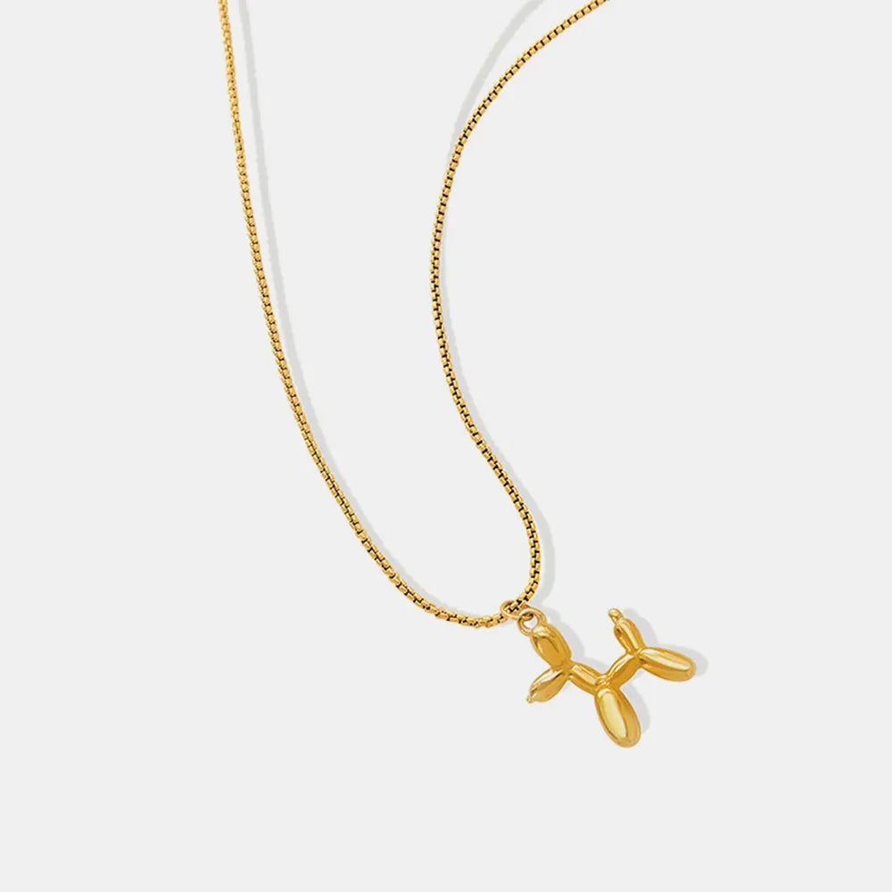 Gold balloon dog pendant necklace on a box chain.