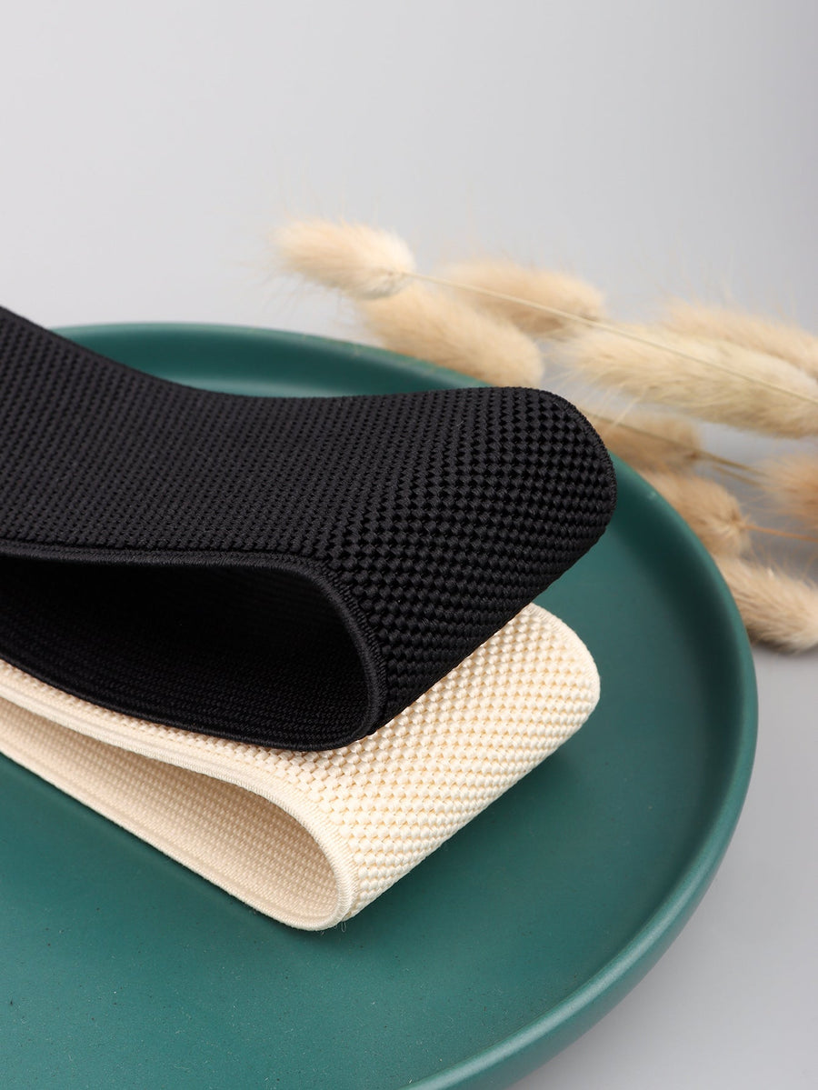 Black and cream elastic belts with textured fabric and gold hardware detail