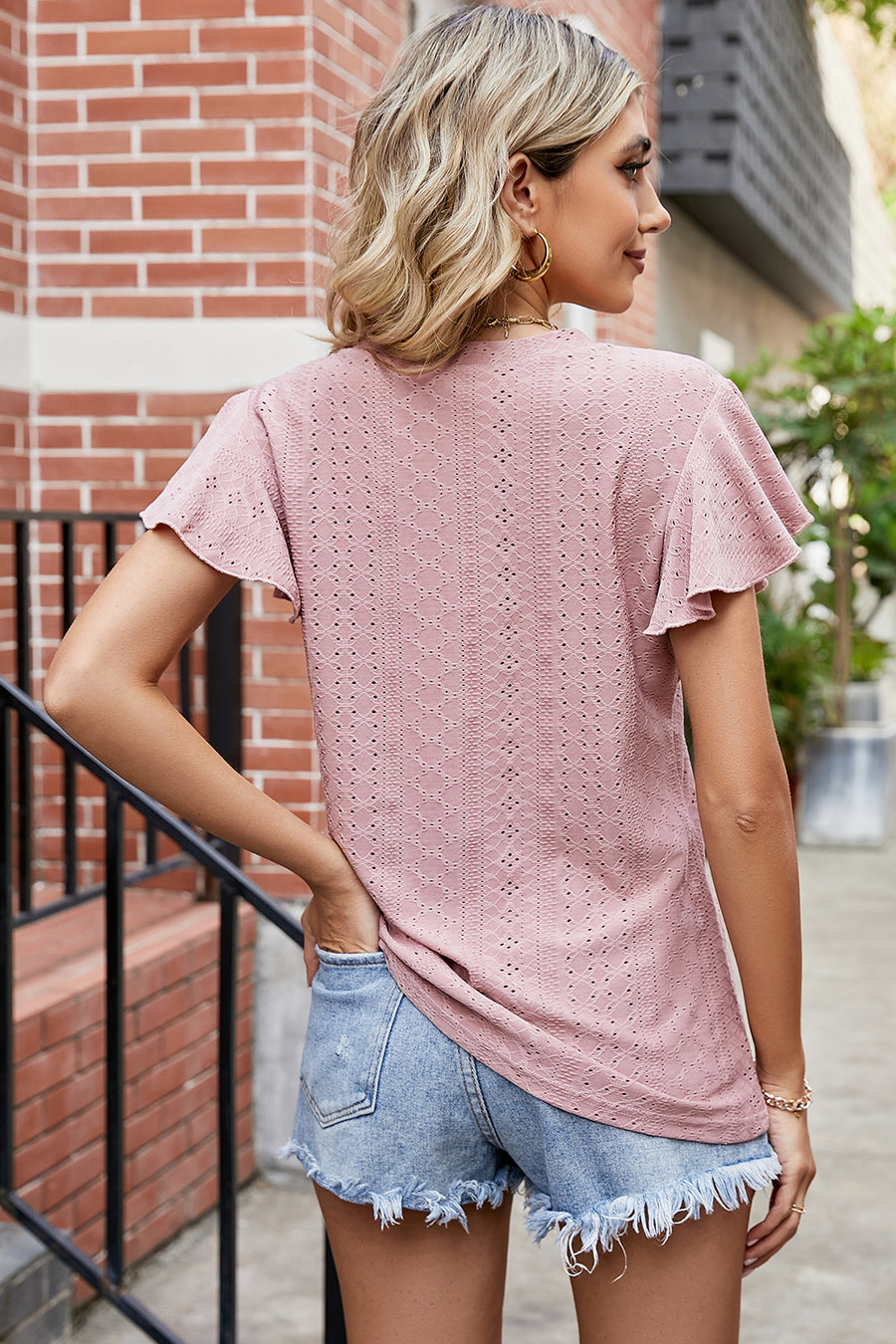 Flutter sleeve eyelet top in watermelon pink with a textured pattern.