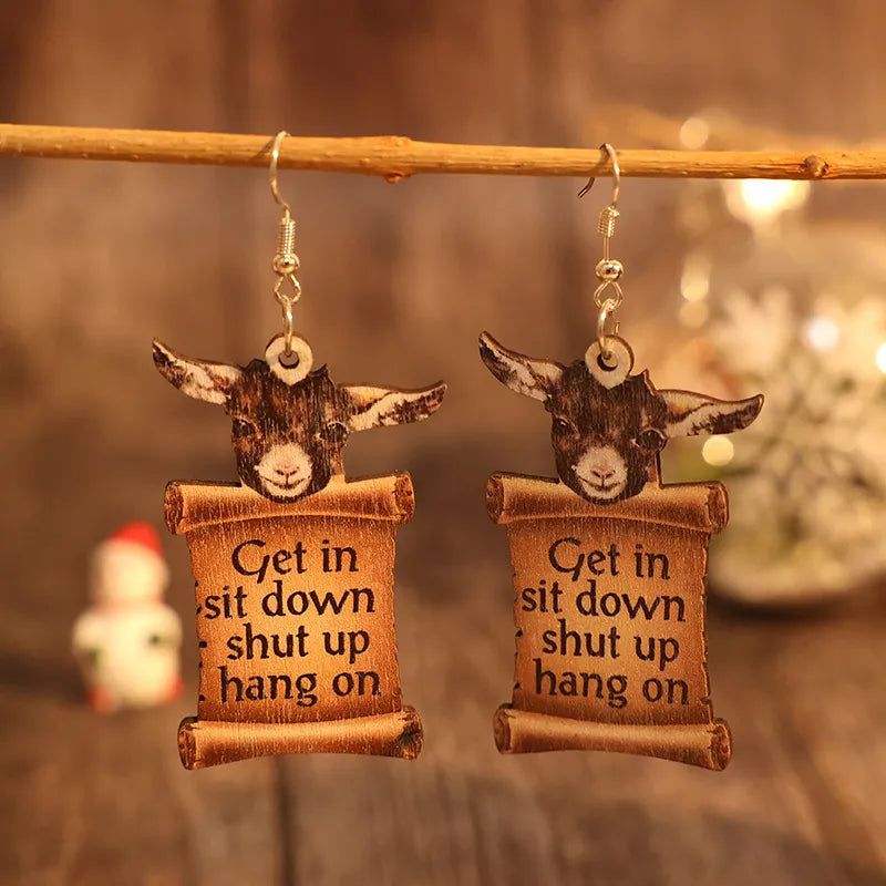 Goat head scroll drop earrings with text, camel colored, wood material.