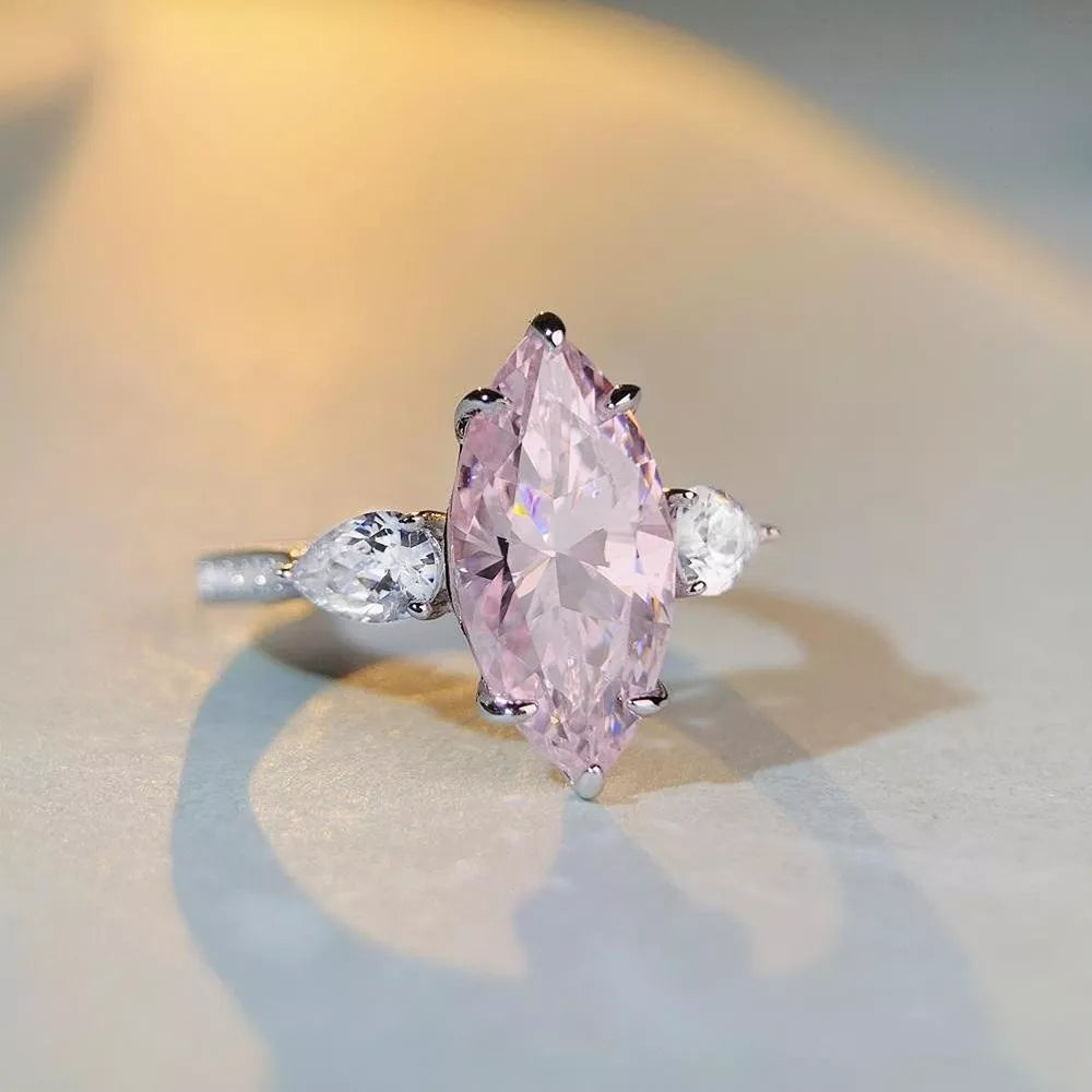 ring in pink featuring marquise cut stone and three-stone fit