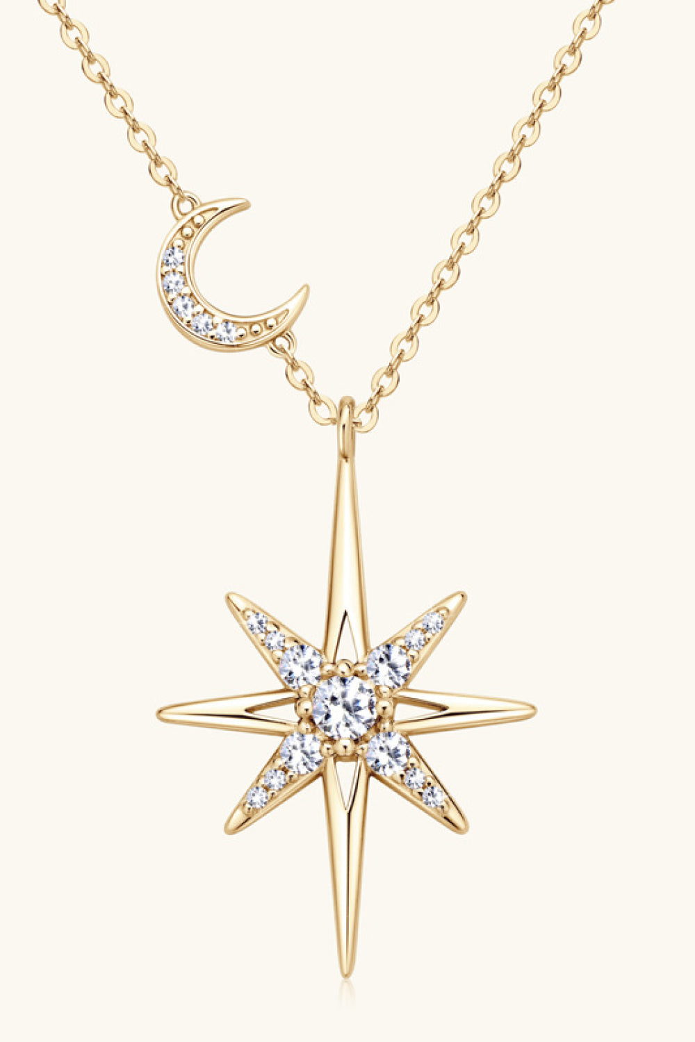 Gold celestial starburst pendant necklace with a crescent moon charm and clear crystals.