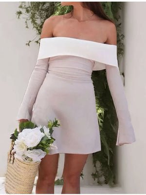 Eggshell off-shoulder dress with flare sleeves and a-line skirt, styled with a straw bag and flowers.