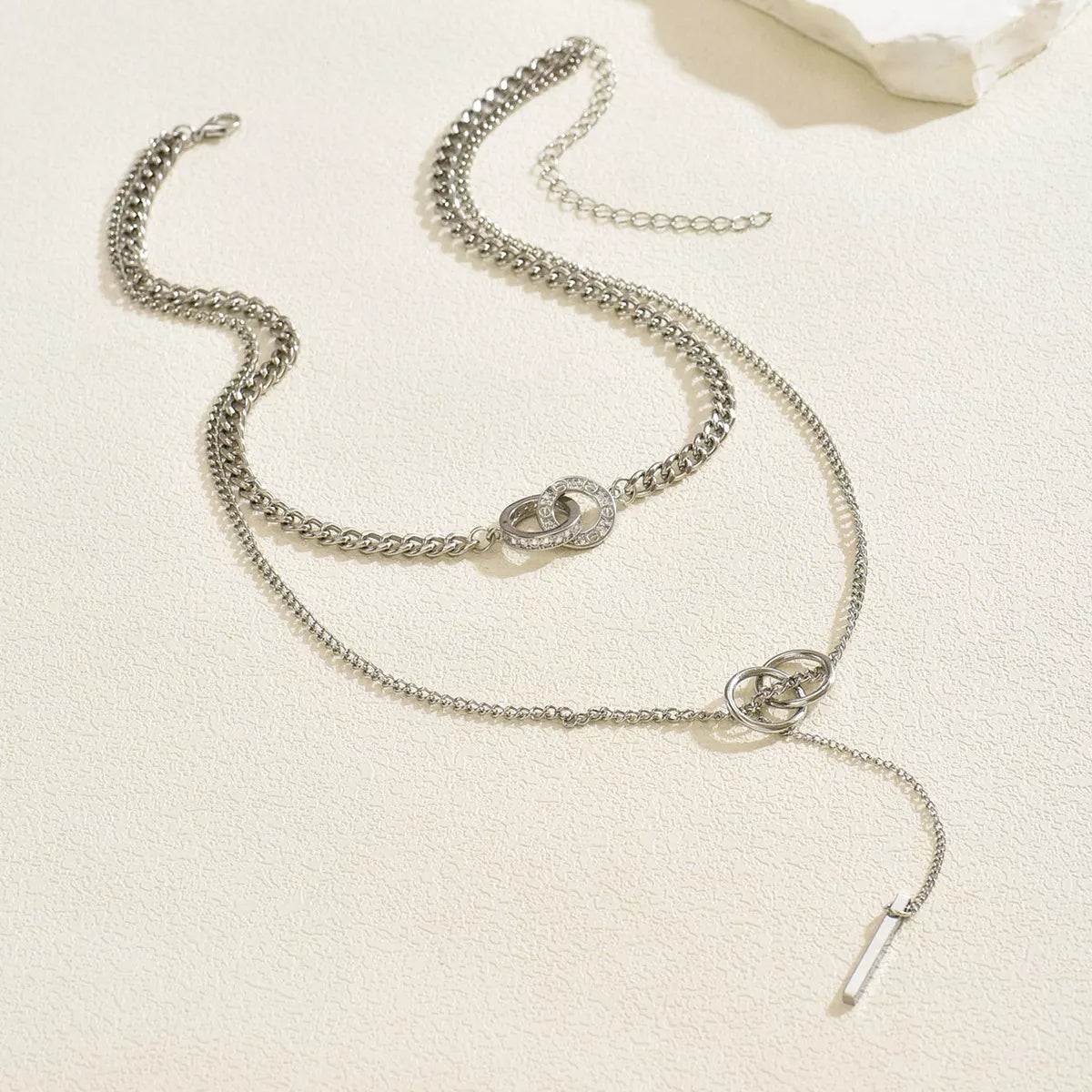 Silver layered Y-shaped pendant necklace with interlocking rings and cubic zirconia detail.