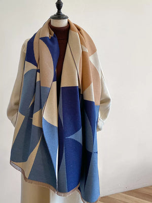 Geometric patterned soft scarf in light indigo and beige with fringe details.