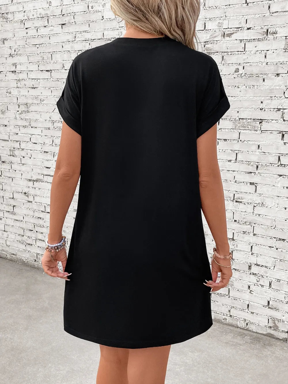 Black graphic tee dress with cuffed short sleeves and a casual fit.