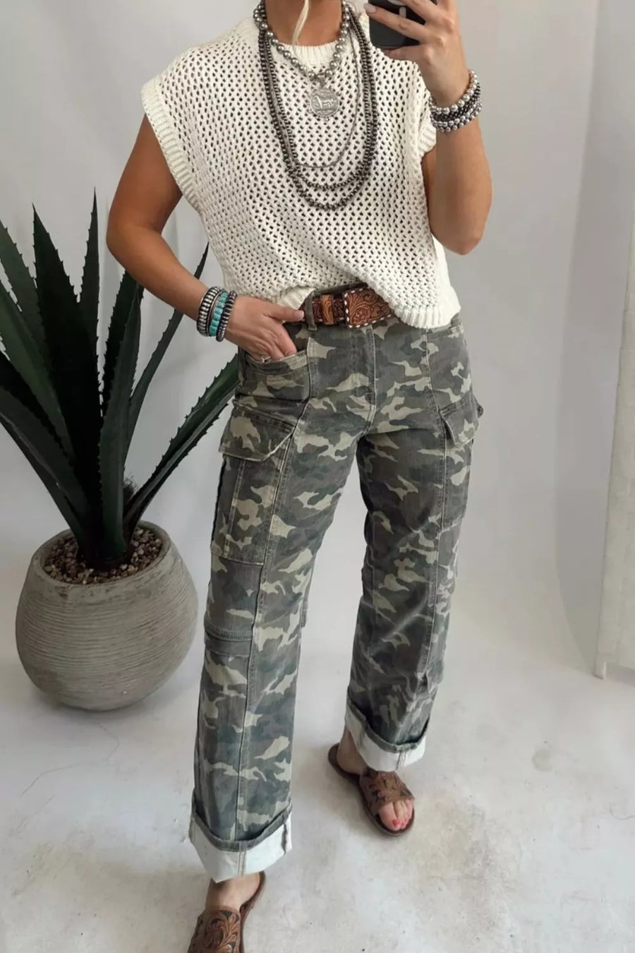 Camo print cargo jeans with cuffed ankles and utility pockets.