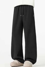 Black relaxed wide-leg sweatpants with drawstring and curved seam detail.